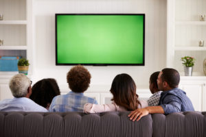 Multi generation family watching TV at home, back view - Baller Alert