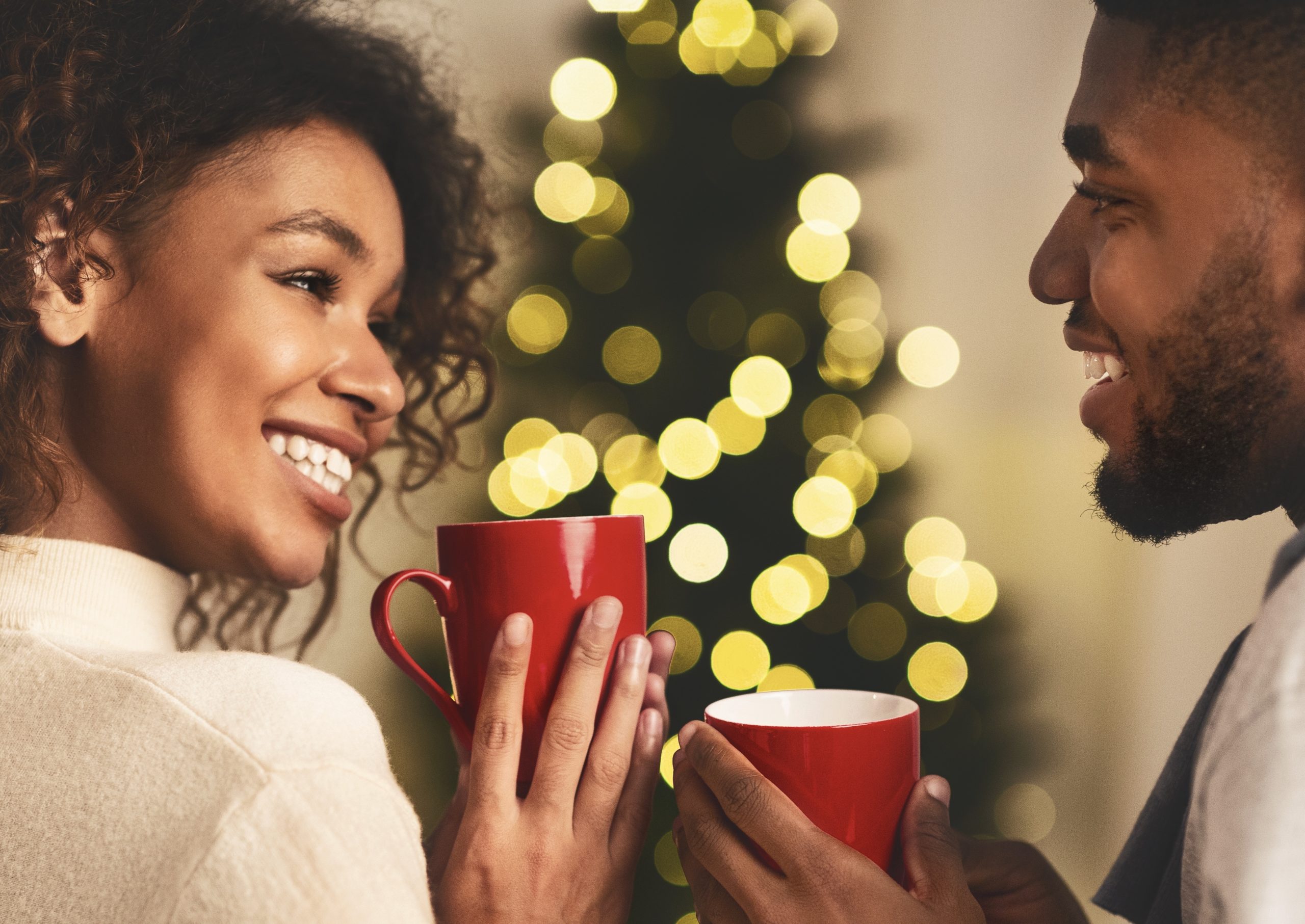 Christmas time. Afro couple talking and drinking tea