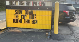 Cop hides behind this sign