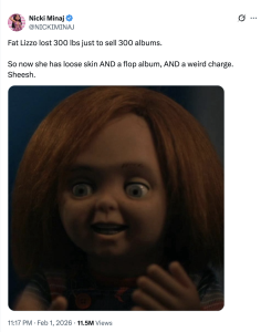 Close-up of a creepy doll's face with orange-red hair, wide eyes, and an open mouth in a surprised expression, wearing a plaid outfit.