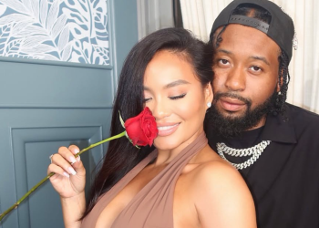 Daphne Joy holding a red rose posing with DJ Akademiks after they linked up