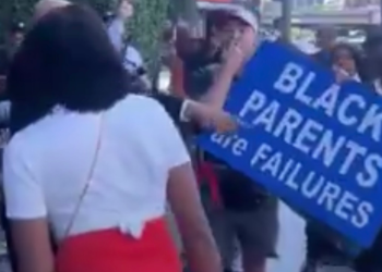 Jake Lang outside the BET Awards at Peacock Theater holding a racist sign