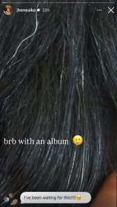 Close-up of dark hair with light streaks; on-screen text says 'brb with an album' with a pleading emoji and a crying emoji.