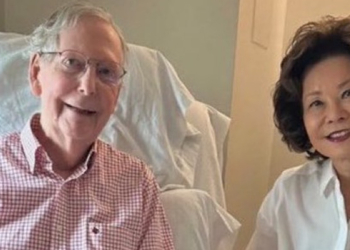 Mitch McConnell sitting in a rehabilitation bed beside his wife Elaine Chao in a photo released with his health update