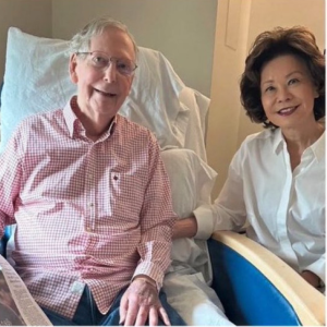 Mitch McConnell sitting in a rehabilitation bed beside his wife Elaine Chao in a photo released with his health update