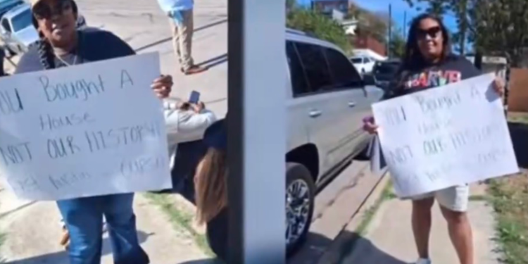 HBCU students protest with signs outside an East Austin home near Huston-Tillotson University