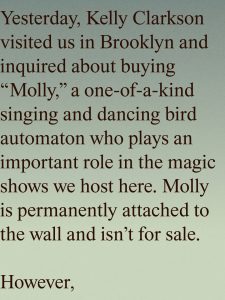 Large serif text on a teal-to-lime gradient background tells a story: Kelly Clarkson visited Brooklyn to inquire about buying Molly, a one-of-a-kind singing and dancing bird automaton crucial to the magic shows; Molly is permanently attached to the wall and not for sale.